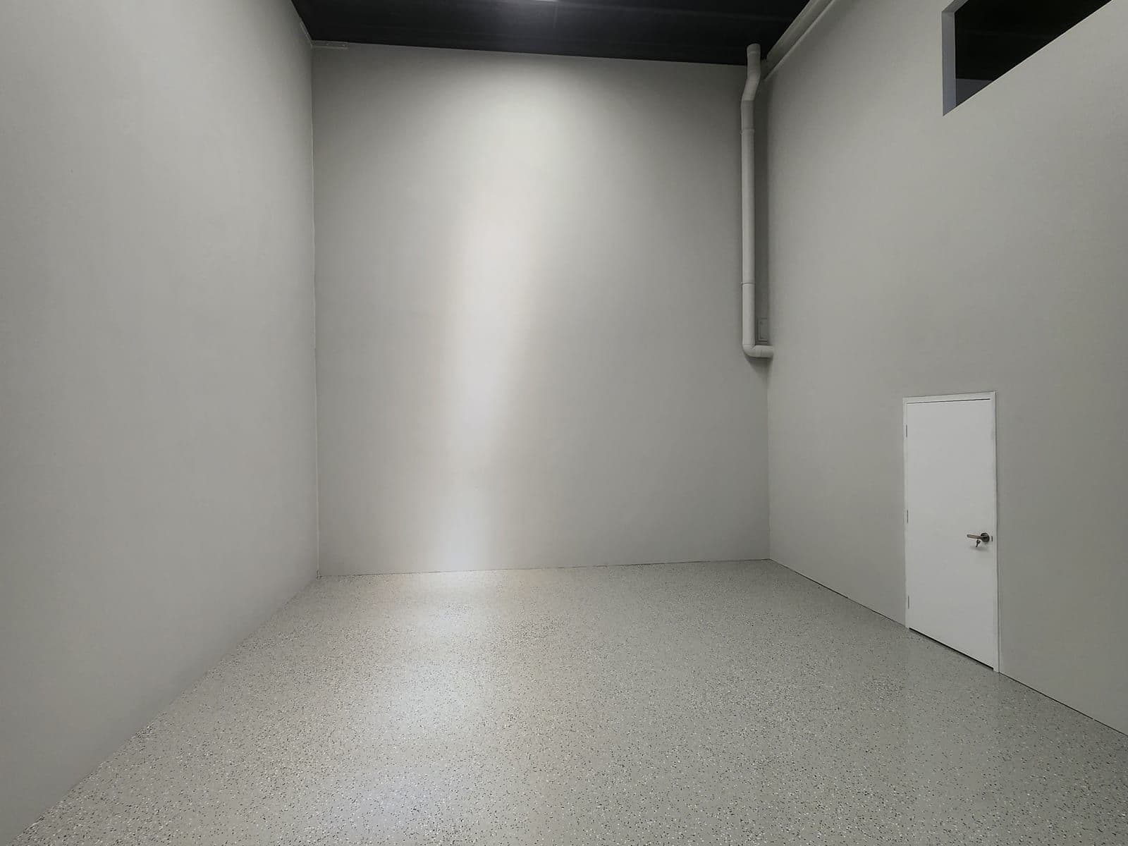 Flake epoxy floor in a dark-walled garage space